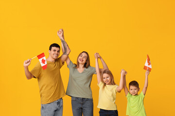 Wall Mural - Beautiful family with flags of Canada on yellow background