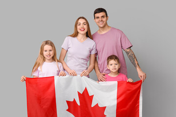 Wall Mural - Happy family with flag of Canada on grey background