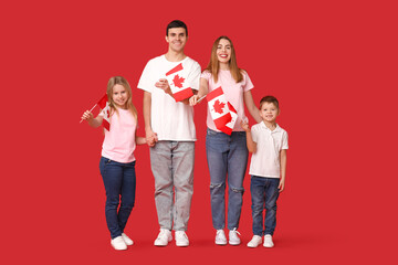 Wall Mural - Beautiful family with flags of Canada on red background