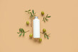 Bottle of cosmetic product with olives on brown background
