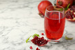 Tasty pomegranate juice in glass and fresh fruits on white marble table. Space for text