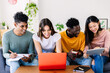 Young group of diverse students studying together using laptop at home - College multiracial people working on university group assignment homework project in modern apartment