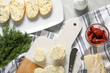 Tasty butter with dill, chili peppers, bread and knife on grey marble table, top view