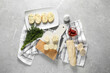 Tasty butter with dill, chili peppers, bread and knife on grey marble table, top view