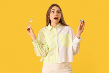 Canvas Print - Shocked young woman with eyeglasses on yellow background