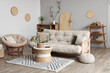 © Pixel-Shot - Stylish interior of light living room with bamboo stems on coffee table, armchair and white sofa