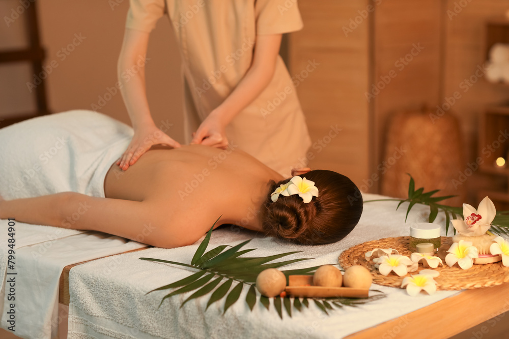 Young woman getting back massage in spa salon