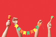 Hands with maracas and garland on red background. Cinco de Mayo celebration