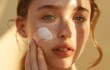 Young beautiful model girl applying sunscreen creme on facial skin. Natural Beauty. Cosmetics for summer with SPF protection. Yellow cosmetic product.