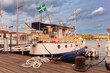 A boat with Swedish flag docked along waterfront, Stockholm, Sweden