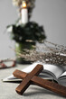 Bible and wooden cross on grey table, closeup