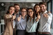 © Chacmool - Group of young business people standing in office and showing thumbs up.