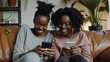 © Bnetto - Happy girl and mother sit on sofa with smartphone in video conference chat event with family.