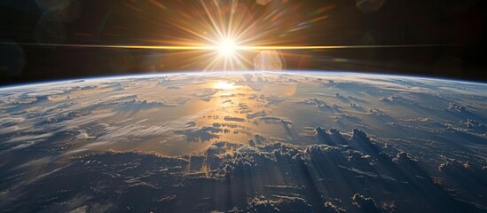 Wall Mural - The sun is rising over the beautiful blue planet Earth as seen from outer space, creating a stunning view
