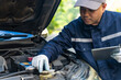 © BJ Day Stock - Asian automobile mechanic repairman wearing uniform and protection glove repairing a car engine automotive workshop with tablet, car service and maintenance, Repair service.