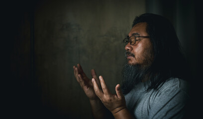 Wall Mural - Person man, turned to God in prayer, demonstrating their religious faith and devotion through worship. Man hand in prayer, expressing his religious faith in God through worship of Jesus Christ.