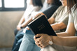 Group of Christian women sat together in chairs, holding their Bibles, feeling the togetherness of prayer and their religious connection to God. Group christian pray concept.