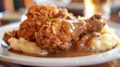 A plate of crispy fried chicken served with mashed potatoes and gravy