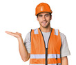© Asier - Young Hispanic worker in safety gear showing a copy space on a palm and holding another hand on waist.