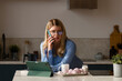 Woman on phone with breakfast in kitchen