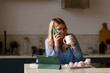 Woman using phone in kitchen with coffee