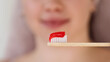 Close-up of red toothpaste on bamboo brush.