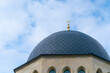 Close-up shot of the gambiz dome with a crescent moon on top of a Muslim mosque against a blue sky