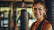 Beautiful athletic woman stands hugging a punching bag in a fitness gym