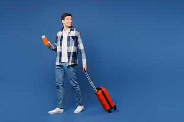 Poster - Traveler man wears shirt casual clothes hold bag passport ticket look aside isolated on plain blue background. Tourist travel abroad in free spare time rest getaway. Air flight trip journey concept.