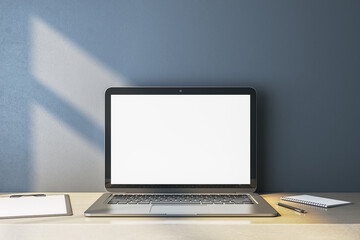 Poster - Close up of empty white computer monitor on simple wooden desk. Blue wall background. Workplace concept. Mock up, 3D Rendering.