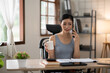 © Thitisak - Asian woman talking on the phone, working with customers, office