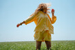 © Westend61 - Woman wearing yellow linen clothing with tousled hair in blooming field on sunny day