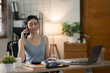 © Thitisak - ฺAsia Businesswoman sitting and working using laptop to chat with customers online in office