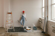 © Westend61 - Woman leaning on white wall near ladder and paint equipment in new apartment