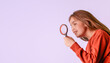 A girl is holding a magnifying glass and looking at something. Copy space left. Banner on pink