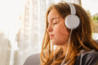 Romantic portrait of a teenage girl in a routine setting. A girl is wearing headphones and listening to music