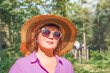 Portrait of a beautiful middle-aged woman in a summer park against a background of nature