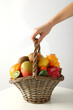 Set of tropical fruits in basket in hand on white background