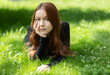Beautiful girl with red hair enjoying summertime in the park.
