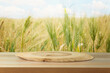 Empty wooden log on table over wheat field background. Jewish holiday Shavuot mock up for design and product display