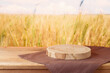 Empty wooden log with tablecloth on table over wheat field background. Jewish holiday Shavuot mock up for design and product display