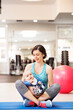Portrait of new mom on group exercise class in gym. Moms staying active while boding with babies.