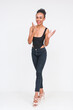 Happy mixed-race woman in bodysuit and jeans on white background