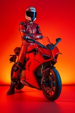 Motorcyclist In Red Gear Posing With Sports Bike
