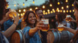 A group of friends celebrating at an outdoor beer festival, toasting with large glasses and pints of fresh keg foamy lager beer on the table in front of them.
