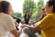 © Aida - therapy of women participating in support group session, sitting on the floor and holding hands