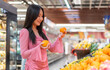 Portrait of beauty asian happy woman relax and enjoy shopping time with trolley cart buy healthy food package of grocery food with clean vegan eating vegetable and fruit at shopping supermarket