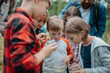 © Halfpoint - Young students analyzing water quality, ph level with indicator strips during biology field teaching class. Female teacher during outdoor active education.