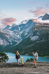 Wall Mural - family walking outdoor traveling together in norway - mother, father and child on summer vacation hi