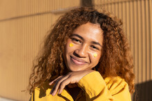 Happy Beautiful Young Curly Haired Woman With Yellow Heart Shape Stickers On Cheeks
